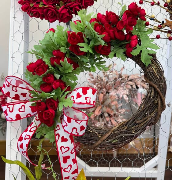 Handmade grapevine wreath with red roses and a heart-print bow